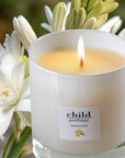 Child Perfume Candle (8 oz) with white flowers in the background