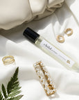 Child Perfume Limited Edition Extrait de Parfum 10 ml shown with gold jewelry and a leaf on a light fabric background