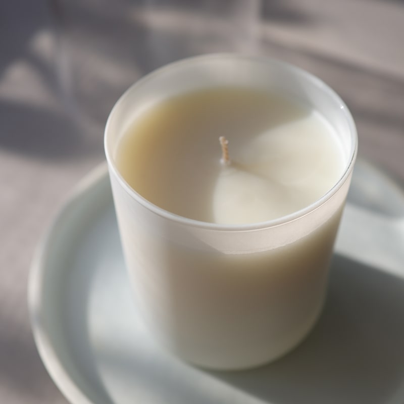 Lifestyle shot of Child Perfume Scented Candle 8 oz shown top angle view on white dish